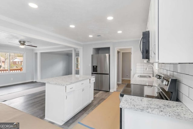 kitchen with sink, white cabinetry, tasteful backsplash, a center island, and appliances with stainless steel finishes