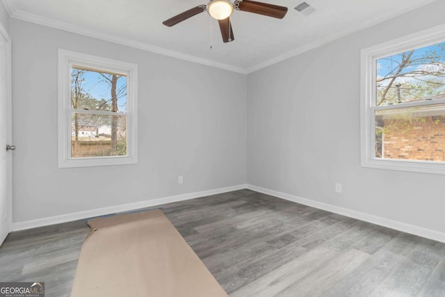 empty room featuring ceiling fan, ornamental molding, dark hardwood / wood-style flooring, and a wealth of natural light