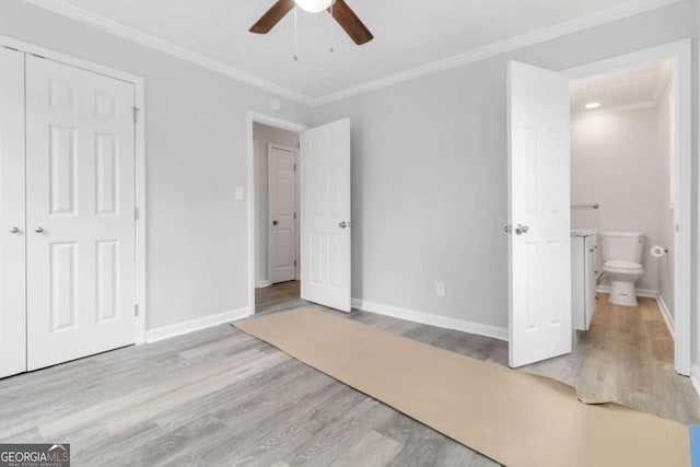 unfurnished bedroom featuring connected bathroom, light wood-type flooring, ornamental molding, a closet, and ceiling fan