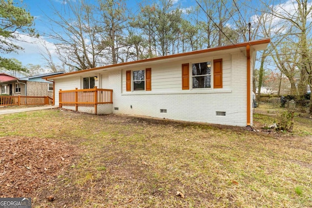 view of front facade with a wooden deck and a front lawn