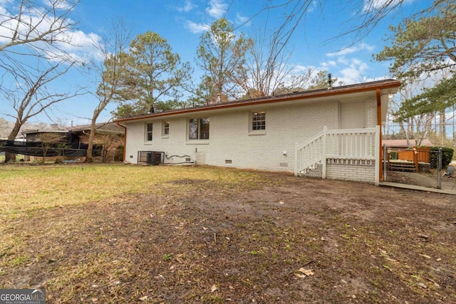 rear view of property featuring cooling unit and a yard