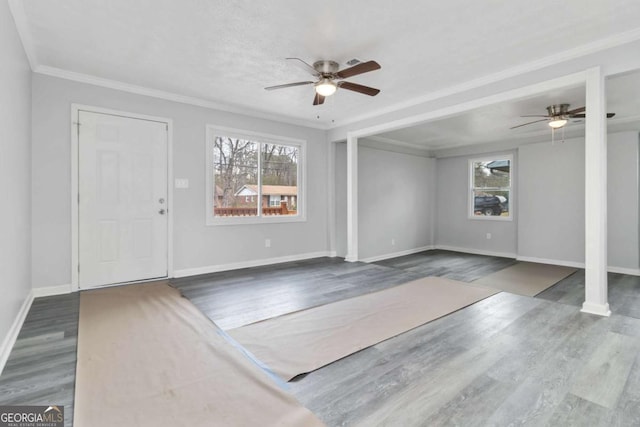 entrance foyer featuring dark wood-type flooring, ceiling fan, a healthy amount of sunlight, and crown molding