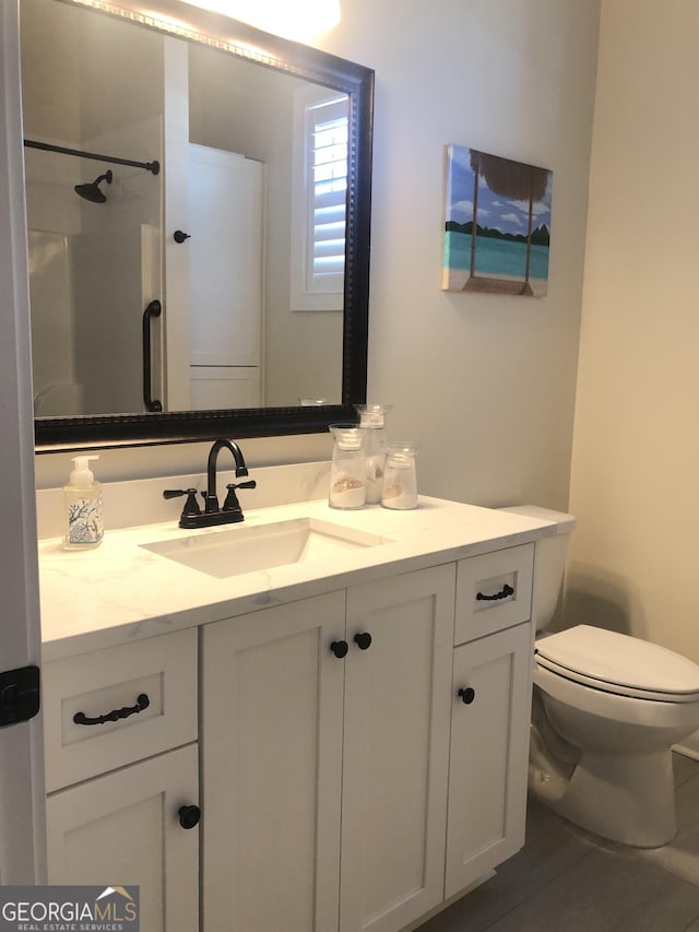 bathroom with vanity, toilet, and walk in shower