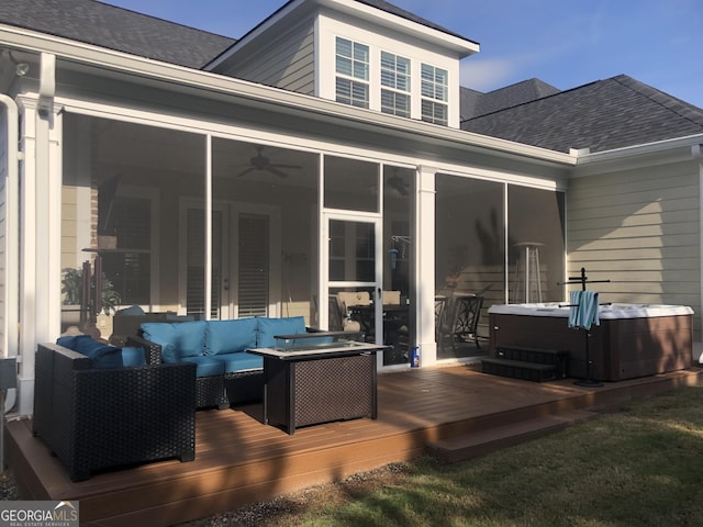 wooden terrace with ceiling fan, an outdoor living space with a fire pit, a hot tub, and a sunroom