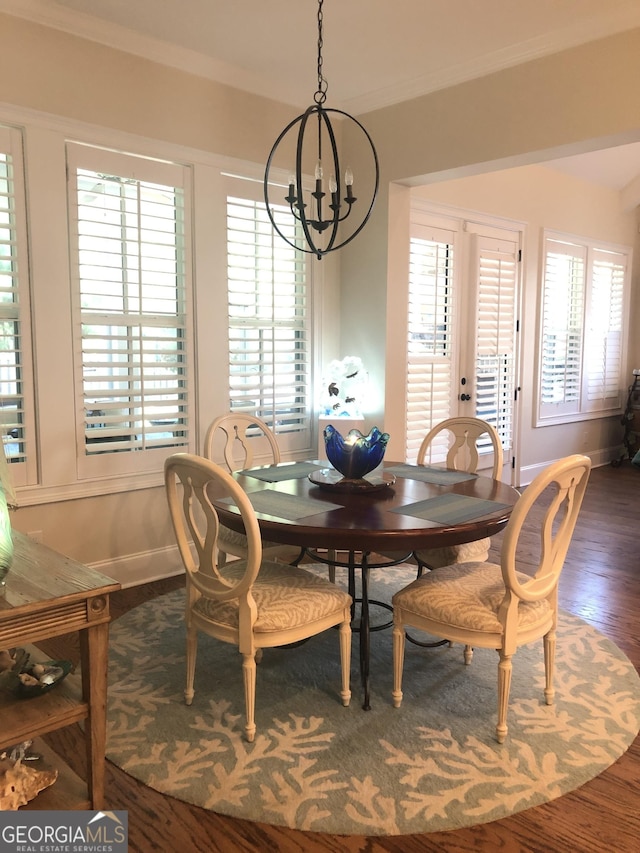 dining space with ornamental molding, plenty of natural light, dark hardwood / wood-style floors, and an inviting chandelier