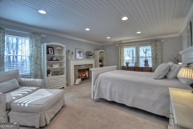 bedroom with ornamental molding, a stone fireplace, carpet, and wood ceiling