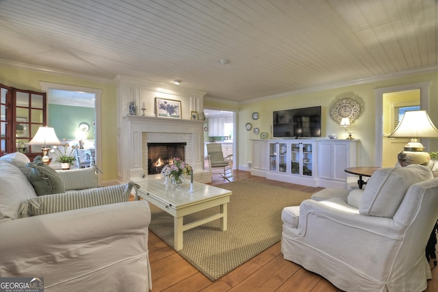 living room featuring light wood-style floors, a brick fireplace, and ornamental molding