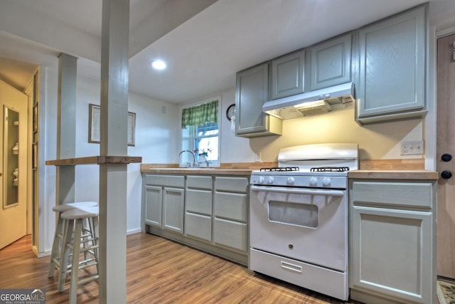 kitchen with butcher block counters, white range with gas stovetop, light wood-type flooring, and gray cabinetry