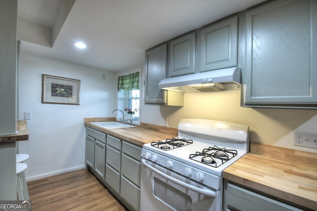 kitchen with wooden counters, sink, gray cabinets, and white gas range oven