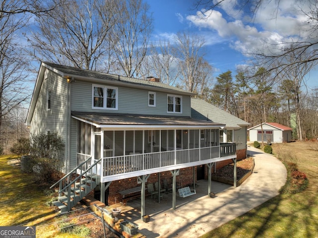 back of property with a sunroom and a patio area