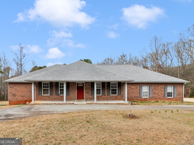 ranch-style home with a front yard and covered porch