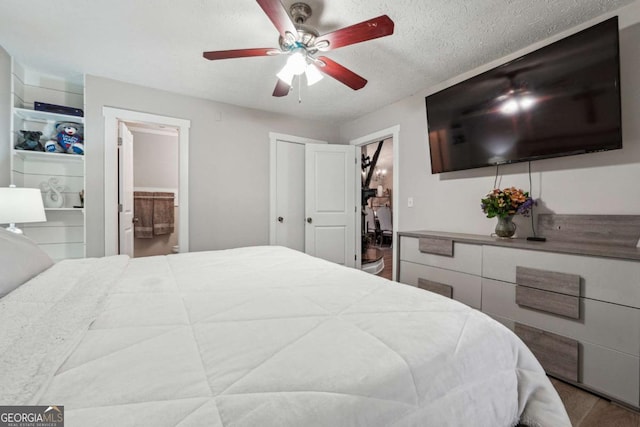 bedroom featuring ensuite bathroom, ceiling fan, and a textured ceiling