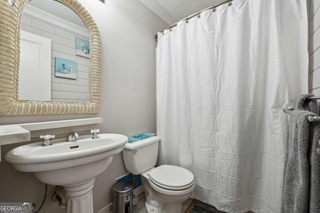 bathroom featuring a shower with shower curtain, a textured ceiling, and toilet