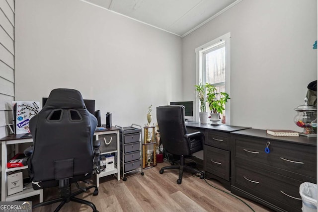 home office with ornamental molding and light hardwood / wood-style floors