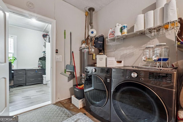 laundry room featuring washing machine and clothes dryer, hardwood / wood-style floors, and gas water heater