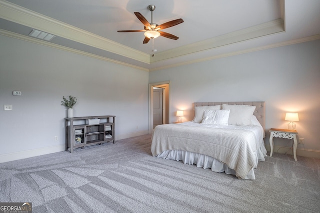 bedroom featuring a tray ceiling, ornamental molding, ceiling fan, and carpet