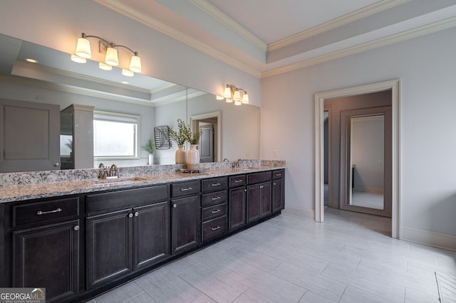 bathroom with a raised ceiling, vanity, and ornamental molding