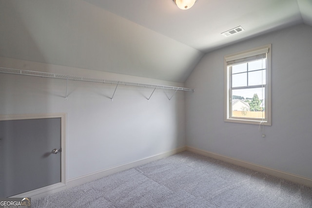 walk in closet featuring vaulted ceiling and carpet