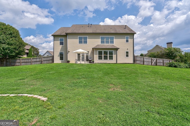 rear view of house featuring a lawn