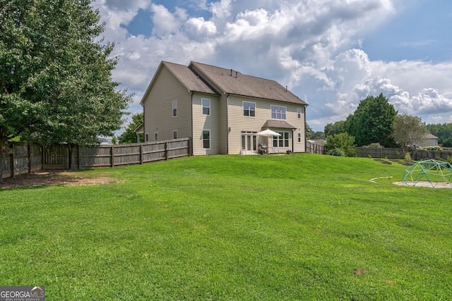 rear view of property featuring a lawn