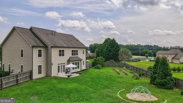 back of house with a lawn and a patio