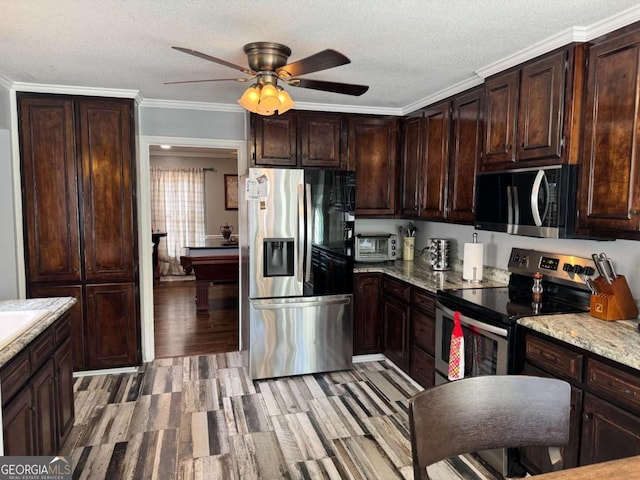 kitchen with appliances with stainless steel finishes, ornamental molding, dark brown cabinetry, light stone countertops, and a textured ceiling