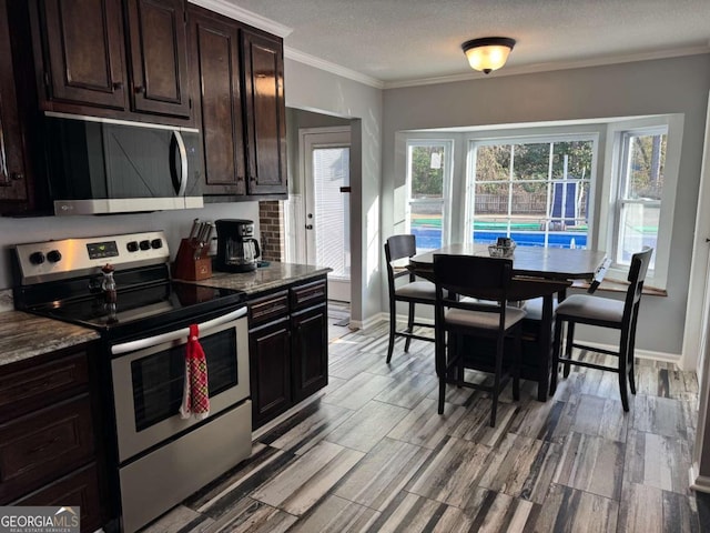 kitchen with stainless steel appliances, dark brown cabinetry, light stone counters, ornamental molding, and a textured ceiling