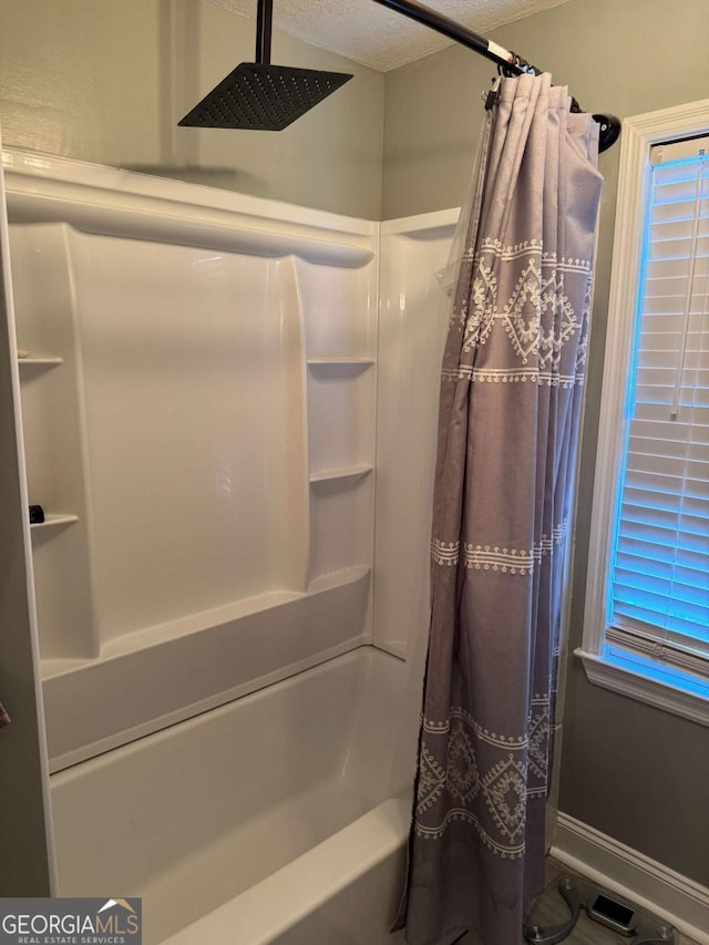 bathroom featuring shower / bath combination with curtain and a textured ceiling