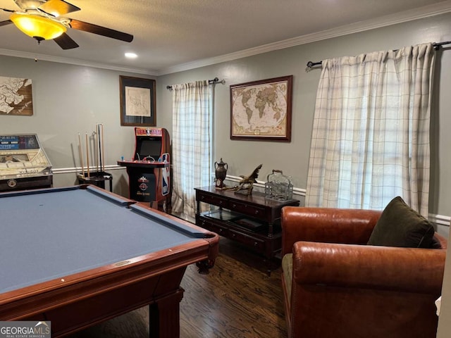 recreation room featuring ceiling fan, ornamental molding, dark hardwood / wood-style floors, and a textured ceiling