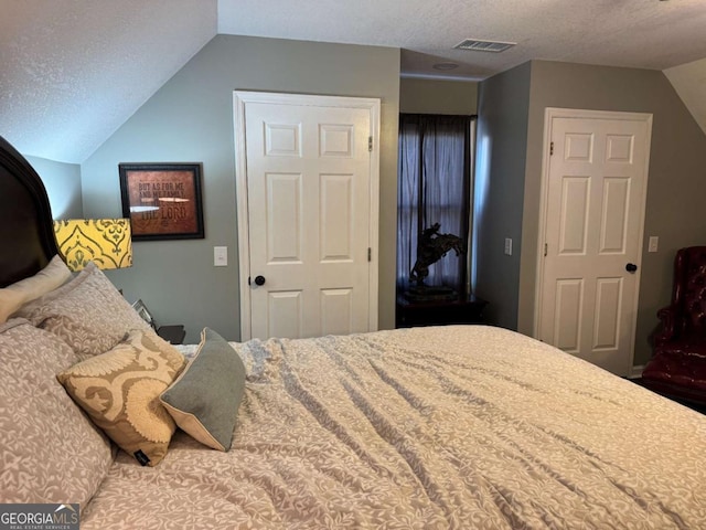 bedroom featuring vaulted ceiling, a closet, and a textured ceiling