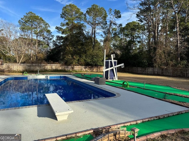 view of pool with a diving board