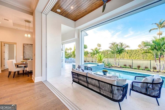 interior space featuring a fenced backyard, outdoor lounge area, a pool with connected hot tub, visible vents, and a ceiling fan