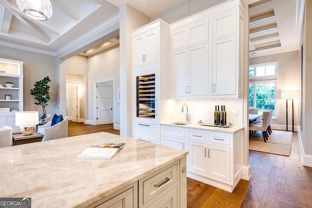 kitchen featuring a sink, wine cooler, wood finished floors, and white cabinets