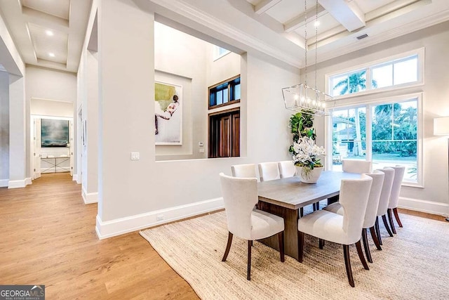 dining area with baseboards, coffered ceiling, a towering ceiling, wood finished floors, and beam ceiling