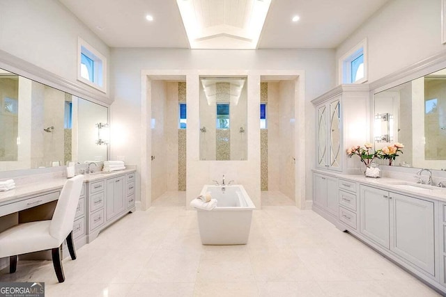 bathroom with a freestanding tub, a sink, and a walk in shower