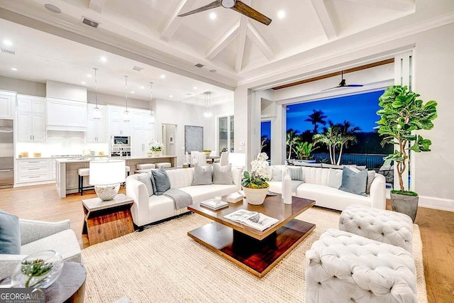 living area with baseboards, visible vents, a ceiling fan, beamed ceiling, and light wood-style floors