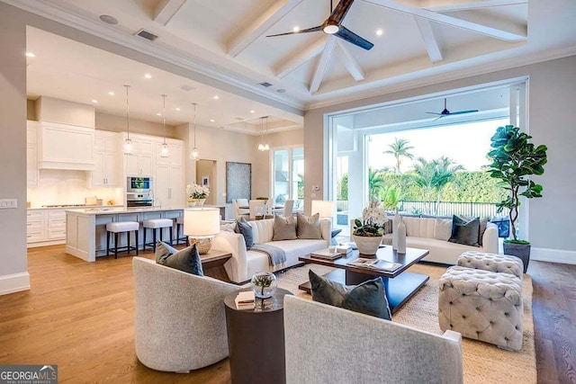 living area featuring light wood-type flooring, baseboards, visible vents, and a ceiling fan