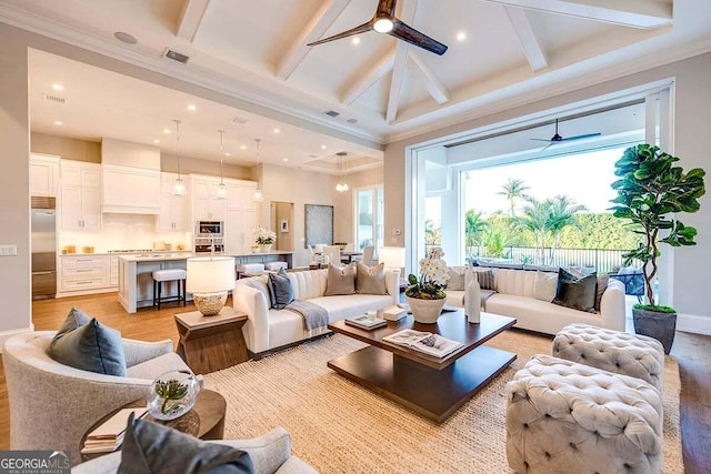 living room with a ceiling fan, beam ceiling, visible vents, and light wood finished floors