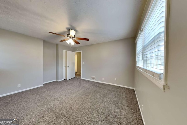 spare room featuring carpet floors, a textured ceiling, and ceiling fan