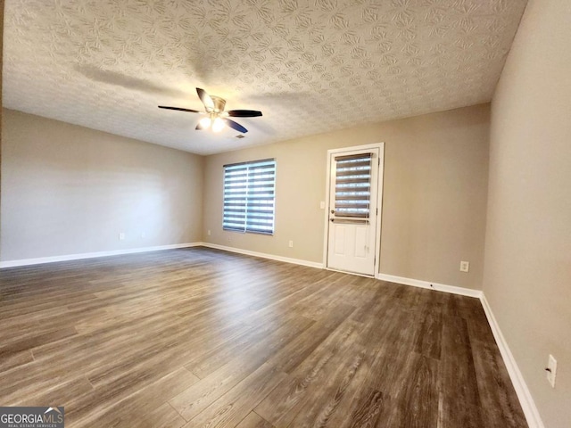 unfurnished room with ceiling fan, wood-type flooring, and a textured ceiling