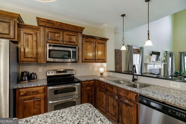 kitchen with pendant lighting, appliances with stainless steel finishes, sink, and tasteful backsplash