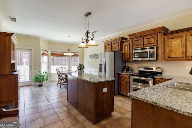 kitchen featuring a center island, stainless steel appliances, light stone countertops, and hanging light fixtures