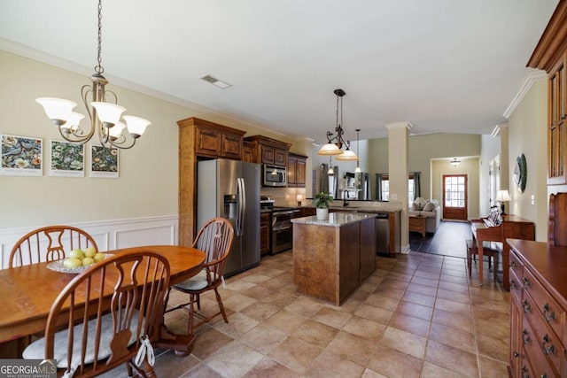 kitchen with decorative light fixtures, light stone counters, kitchen peninsula, stainless steel appliances, and crown molding