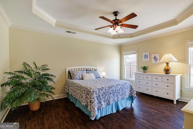 bedroom with a raised ceiling, crown molding, ceiling fan, and dark hardwood / wood-style flooring