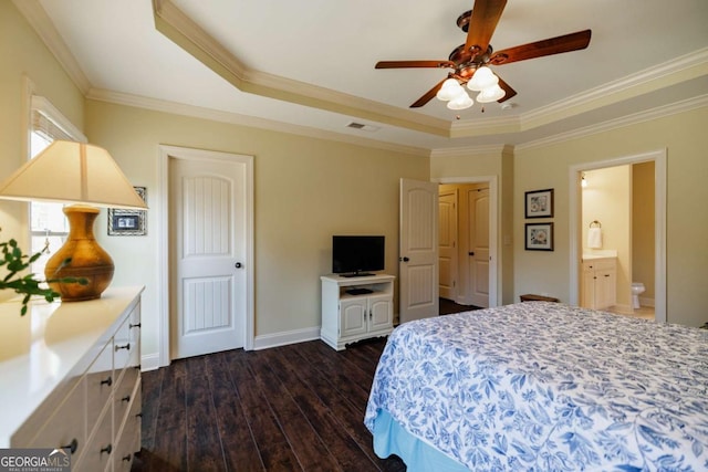 bedroom with connected bathroom, dark hardwood / wood-style flooring, ceiling fan, a tray ceiling, and crown molding