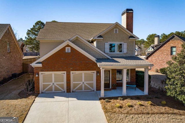 view of front of house with a garage, covered porch, and central air condition unit