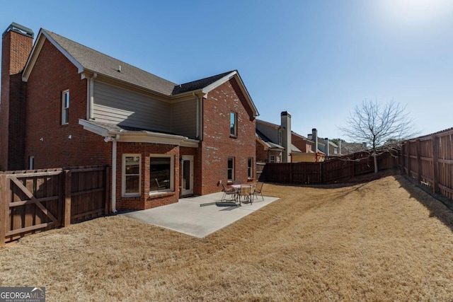 rear view of house featuring a patio area and a lawn