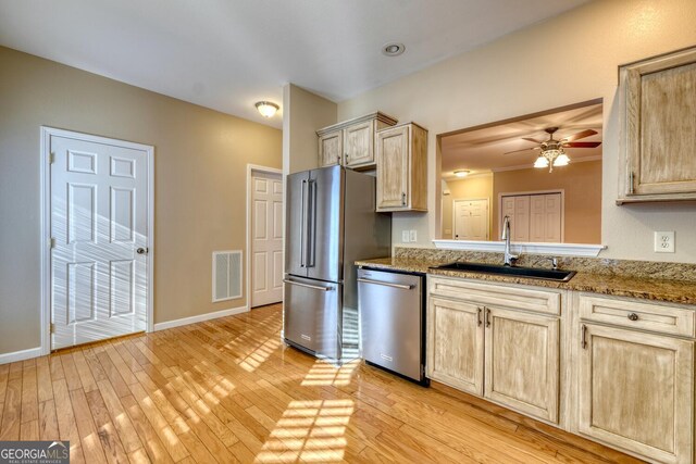 kitchen featuring light brown cabinetry, sink, stainless steel appliances, and stone countertops