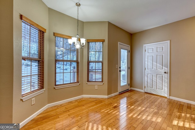 entrance foyer with an inviting chandelier and light hardwood / wood-style floors