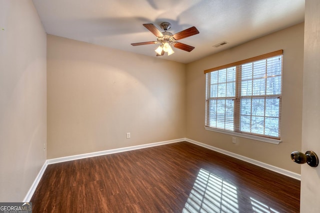 empty room with dark wood-type flooring and ceiling fan